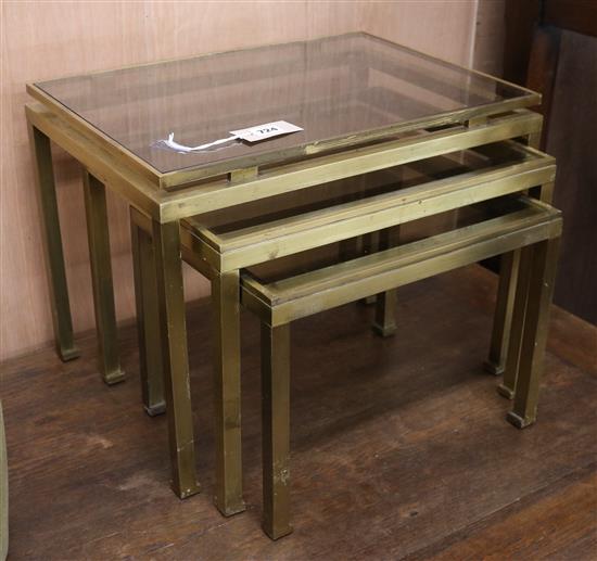Guy Lefevre for Maison Jansen, a nest of three gilt brass, smoked glass tables W.50cm